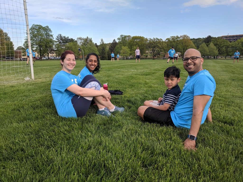 Four Neonatal-Perinatal Medicine Fellowship trainees are seen sitting on a lawn during a wellness activity.