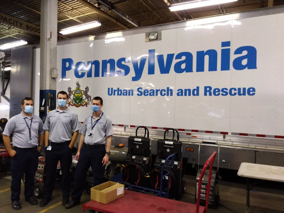 EMS fellows stand in front of a large trailer that says Pennsylvania Urban Search and Rescue.