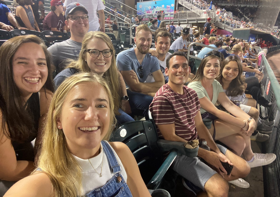 A group of nine residents in various rows and seats smile for the camera at a Harrisburg Senators baseball game.