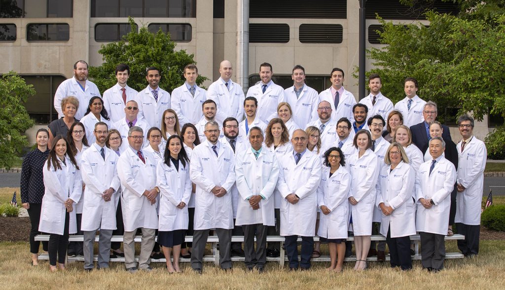 More than 40 members of the Department of Urology, in four rows, pose in the College of Medicine courtyard